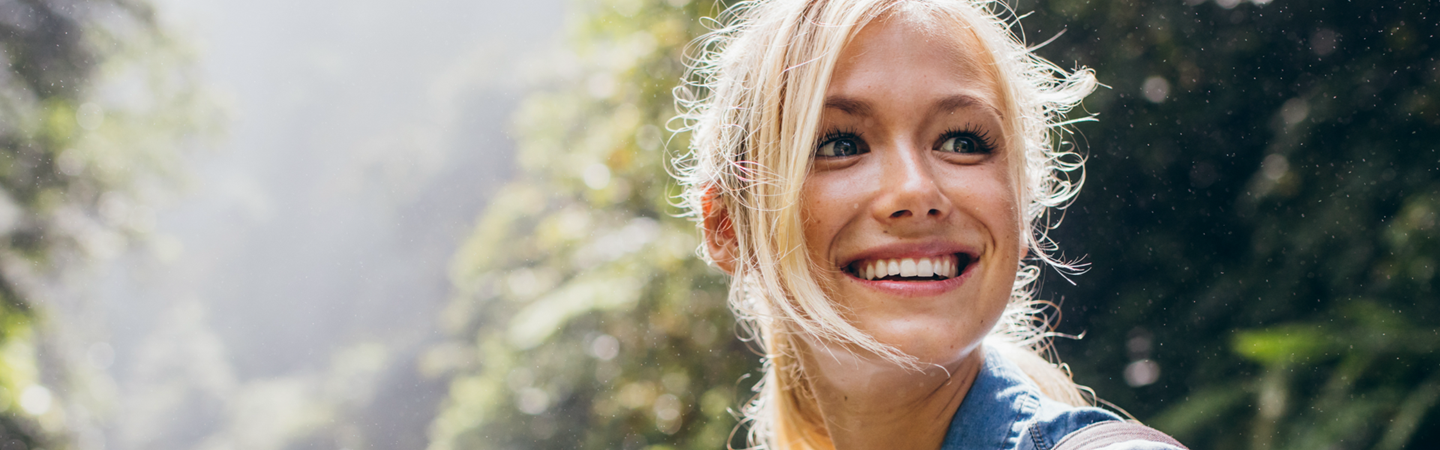 Lady with blonde hair smiling whilst outside